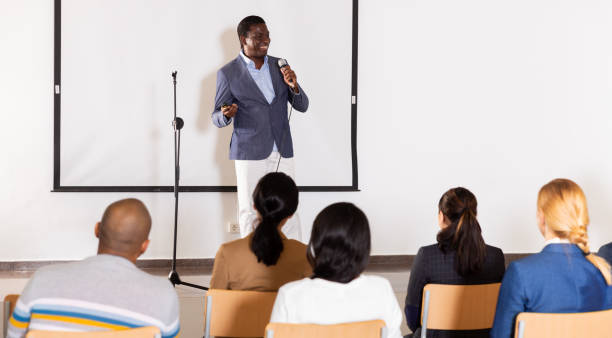 istock Male coach giving speech at conference hall 1301772971