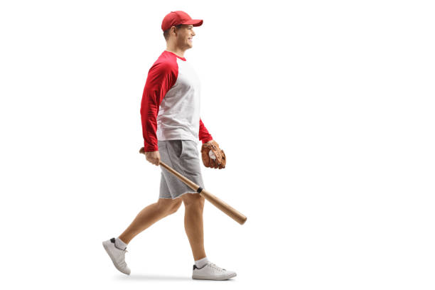 foto de perfil de longitud completa de un hombre con un bate de béisbol y guante caminando - men baseball baseball cap baseball bat fotografías e imágenes de stock