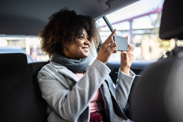 istock Woman taking photos while traveling by a cab 1301774182