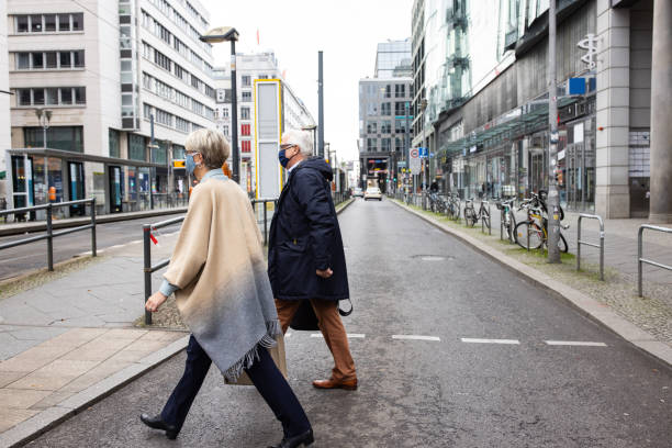 istock Masked commuters crossing a city street 1301774309
