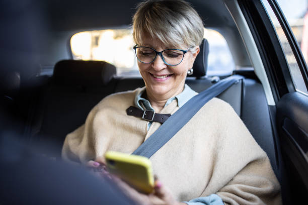 istock Senior woman using her phone during taxi ride 1301774424