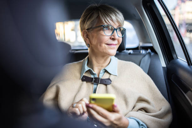 seniorin in der stadt in einem taxi unterwegs - taxi germany car public transportation stock-fotos und bilder