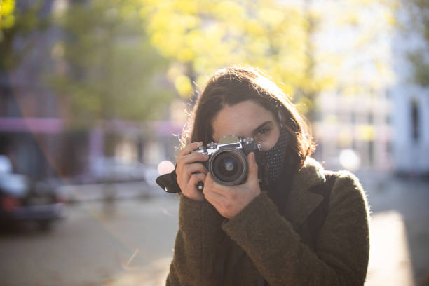 istock Masked woman on vacation taking pictures 1301775218