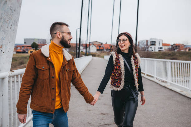 istock Boyfriend holding girlfriend's hand leading her on a footpath having fun 1301775403