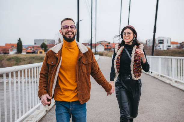 istock Boyfriend holding girlfriend's hand leading her on a footpath having fun 1301775483