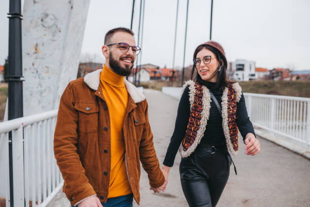 istock Boyfriend holding girlfriend's hand leading her on a footpath having fun 1301775512