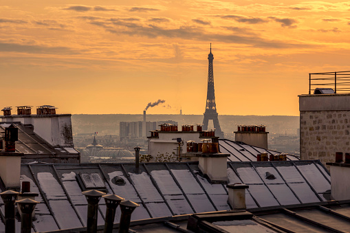 Rare snowy day in Paris. Parisian roofs covered with snow and the Eiffel Tower in the background, view from the Montmartre hill