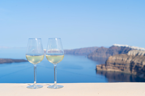 two glasses of white wine with Aegaen sea in background