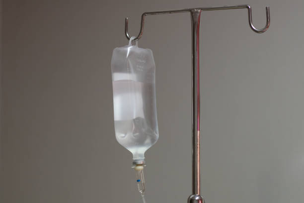 Saline solution bag hang on a metal pole. Saline solution bag hang on a metal pole in the inpatient room at the hospital. saline drip stock pictures, royalty-free photos & images