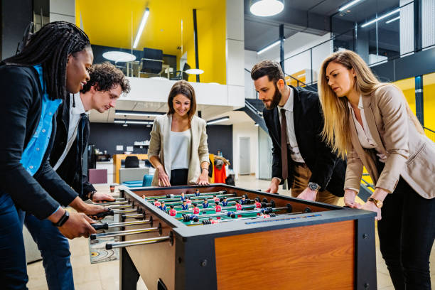 istock Businesspeople playing foosball in office 1301779668