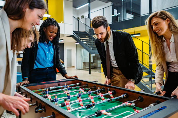 istock Businesspeople playing foosball in office 1301779716