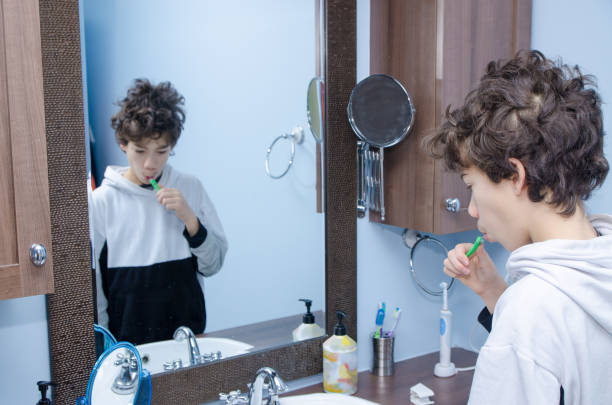 istock Teenage boy brushing his teeth 1301782856