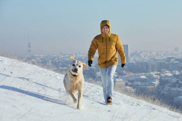 istock Happy young man with dog in winter 1301784417