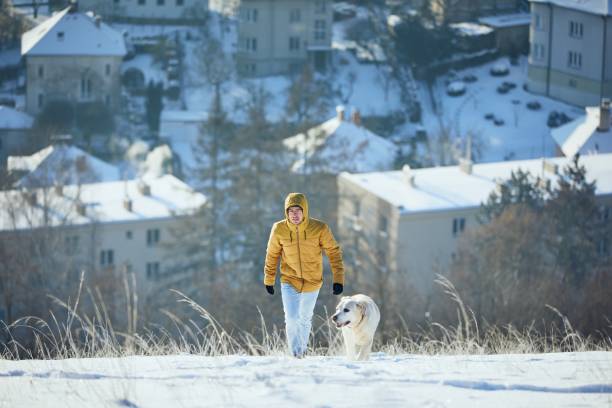 istock Happy young man with dog in winter 1301784482