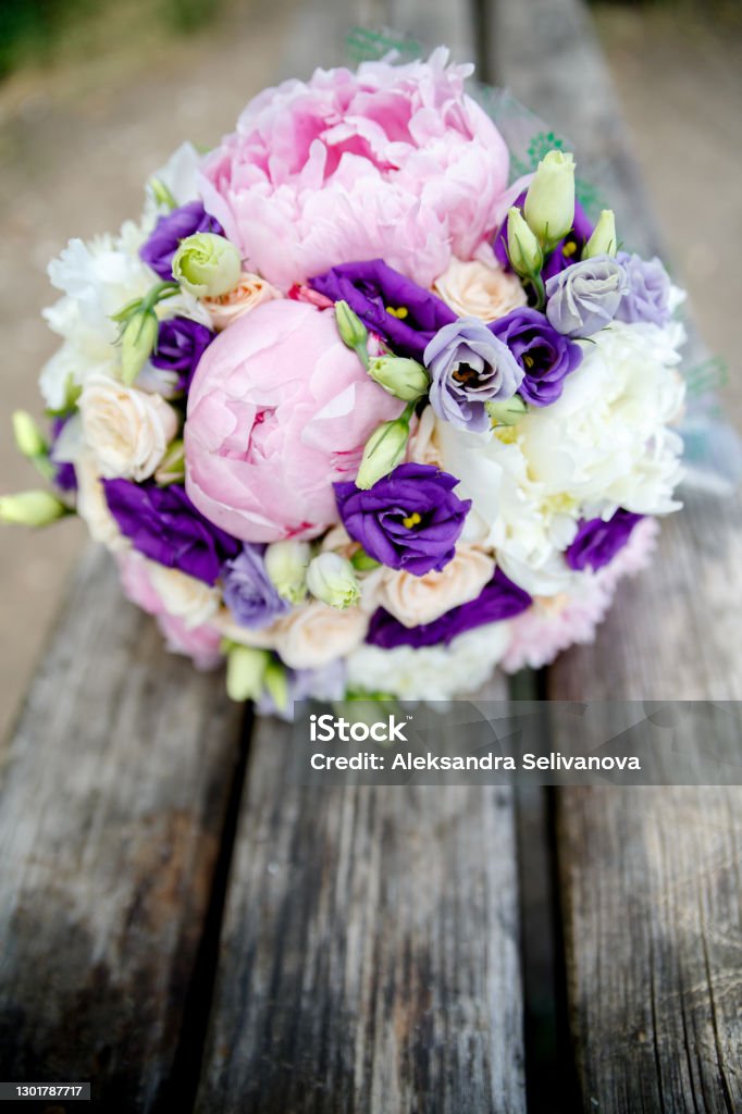 Bridal bouquet of brides from peonies on a wooden background Bridal bouquet of brides from peonies and rose on a wooden background Florist Stock Photo