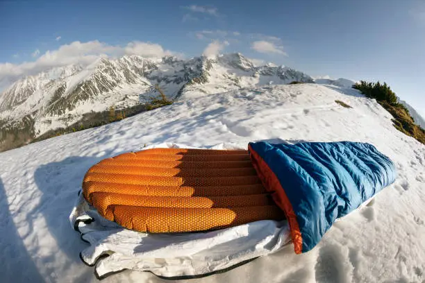 mountaineer is going to spend the night on the top of the mountain in the Tatras in a light bivouac bag on an inflatable mattress. Modern equipment is light and comfortable, safe