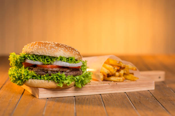 istock Delicious hamburger with vegetables on wooden board 1301789415
