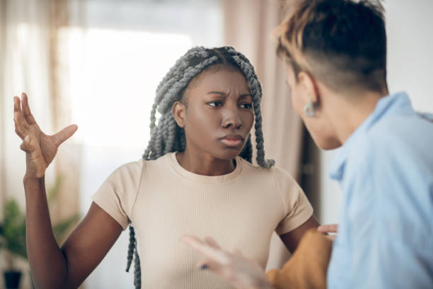 istock Dark-skinned girl talking to her girlfriend and looking agressive 1301789550
