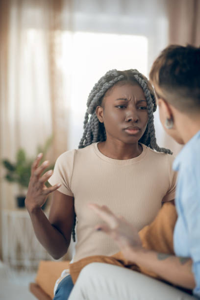 istock Dark-skinned girl talking to her girlfriend and looking agressive 1301789553