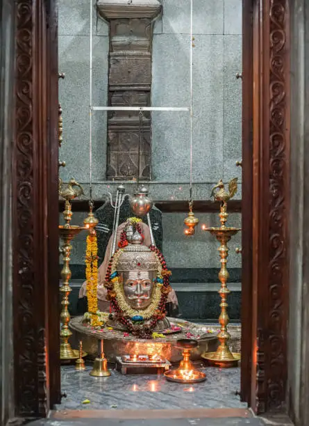 Bagalkot, Karnataka, India - November 8, 2013: Sri Sangameshwar Temple. The essence of sanctuary is Silver Shivalingam with mask, surrounded by burning candles and oil.