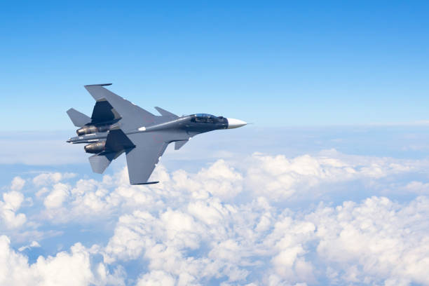el avión de combate vuela girando maniobras en lo alto del cielo por encima de las nubes. - jet fotografías e imágenes de stock