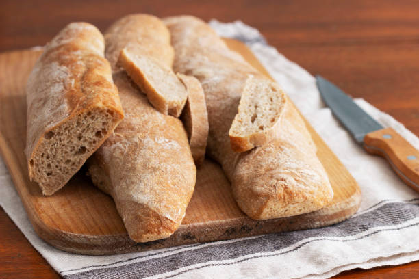 istock Baguette and baguette slices on a wooden table. 1301795494
