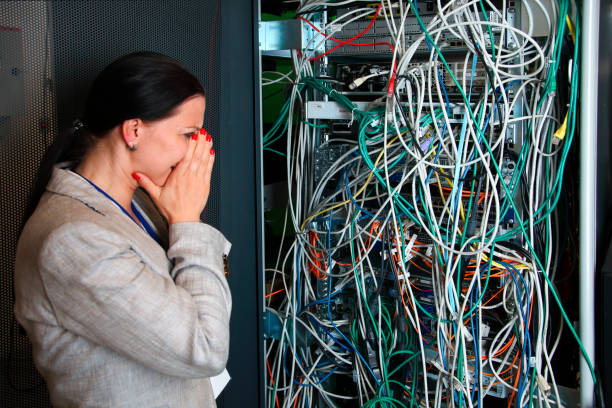 mujer ingeniera tratando de entender el desorden de la red - chaos cable messy electricity fotografías e imágenes de stock