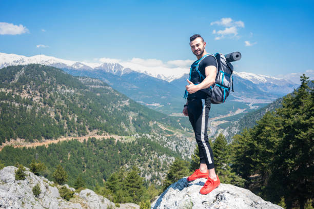 istock Traveler with a backpack standing on a mountain. 1301799488