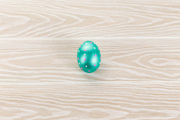 istock Minimal easter card. One easter trendy color decorated egg on wooden white background. Copy space for text. 1301799566