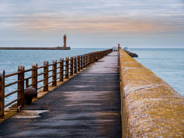 istock View from the pier towards Lighthouse guarding harbour entrance 1301800998
