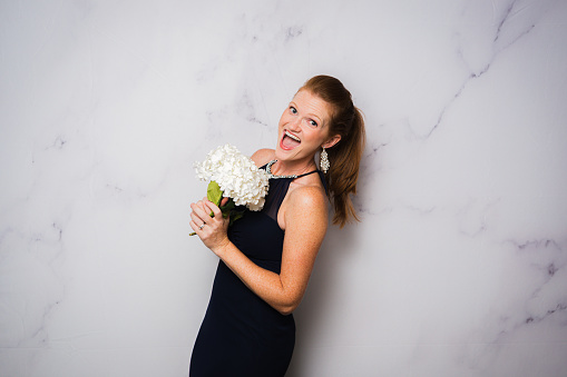 Red Head Bridesmaid with White Flowers against White Marble Backdrop for Photobooth
