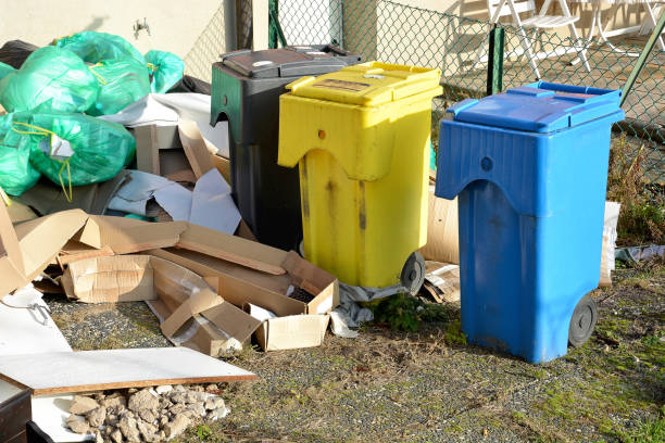 istock There are three trash cans in the backyard - blue for paper, yellow for plastic and packaging, and black for residual waste. Green garbage bags, old cardboard and chipboard boards are scattered around. Garbage sorting concept. 1301805452
