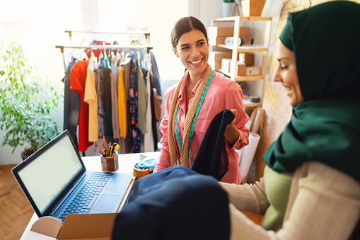 Smiling, young women are working together e-commerce small business from home office.