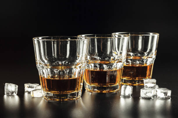 istock Whiskey and ice on rustic wood background 1301808902