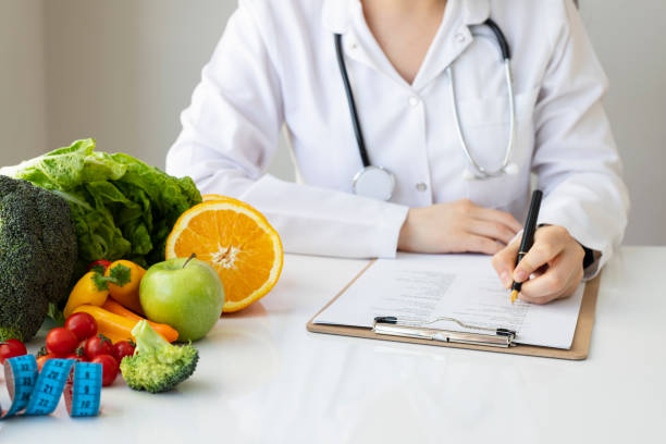 istock Female nutritionist doctor writing vegetable diet plan 1301811073
