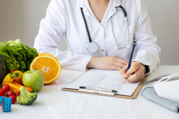 istock Female nutritionist doctor writing vegetable diet plan 1301811084