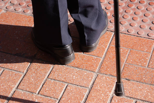 Senior old man and his cane. Closeup of the feet, the cane and the sidewalk. stock photo