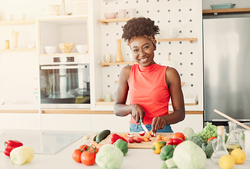 Young woman preparing meal and having fun in the kitchen at home