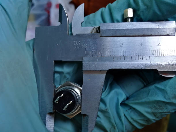 istock Measuring the exact diameter of the button with a caliper with a compass, to clarify the size of the hole 1301816120