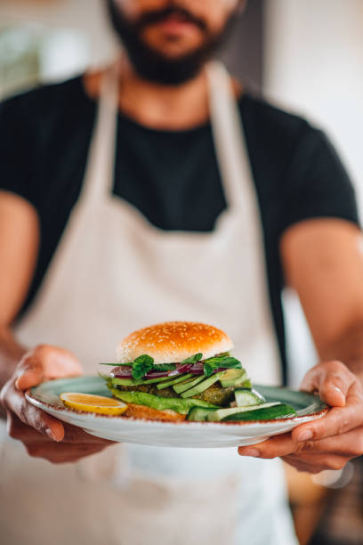 istock Man Holding Vegan Chickpea Burger in Hand 1301818459
