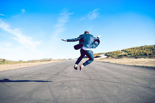 Young Business Male Deciding To Jump In Middle Of Highway