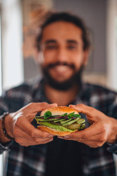 istock Man Holding Vegan Chickpea Burger in Hand 1301820375