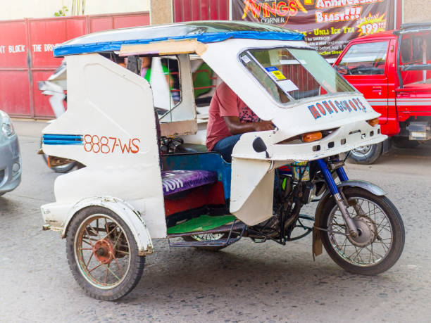 Tricycle vehicle in Philippines Puerto Princesa, Palawan island, Philippines - September 27, 2018: White homemade old tricycle motorbike in Philippines philippines tricycle stock pictures, royalty-free photos & images