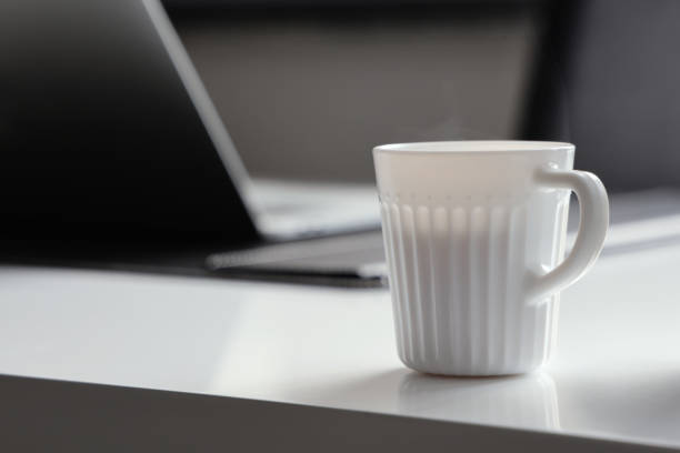 istock Cup of coffee and laptop on the table. 1301823600