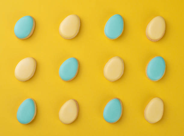 istock Blue and yellow easter egg cookies over yellow background 1301825297