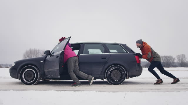 Young couple with breakdown car in winter.