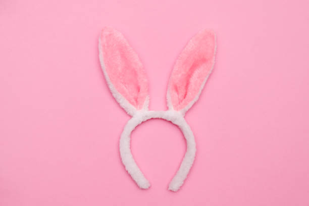 istock Easter bunny. Happy Easter holiday background concept.Flat lay colorful bunny egg with accessory to celebration on modern rustic pink pastel paper at home office desk. 1301826570