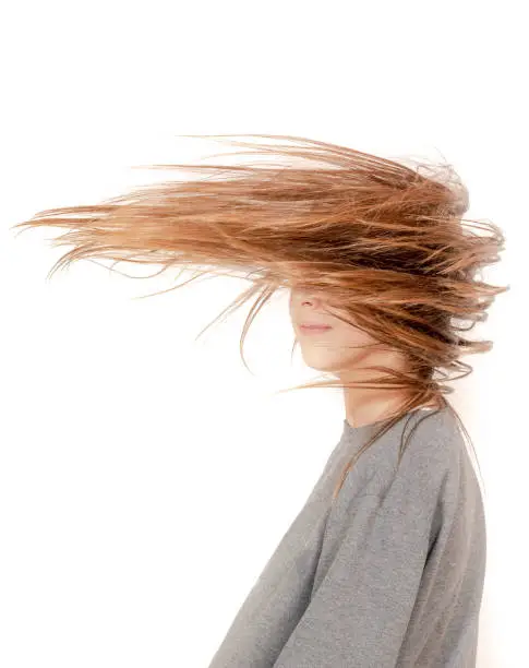 girl whose hair is blowing in the wind over her face