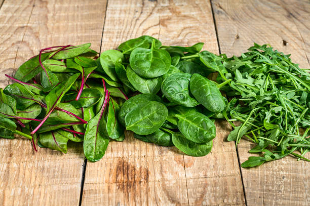 istock Mix Salad leafs, Arugula, Spinach and swiis Chard. Wooden background. Top view 1301830954