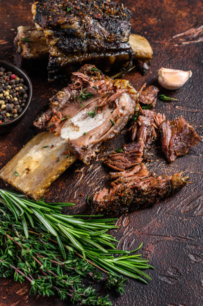 istock BBQ Grilled short beef ribs on a kitchen table. Dark background. Top view 1301833003